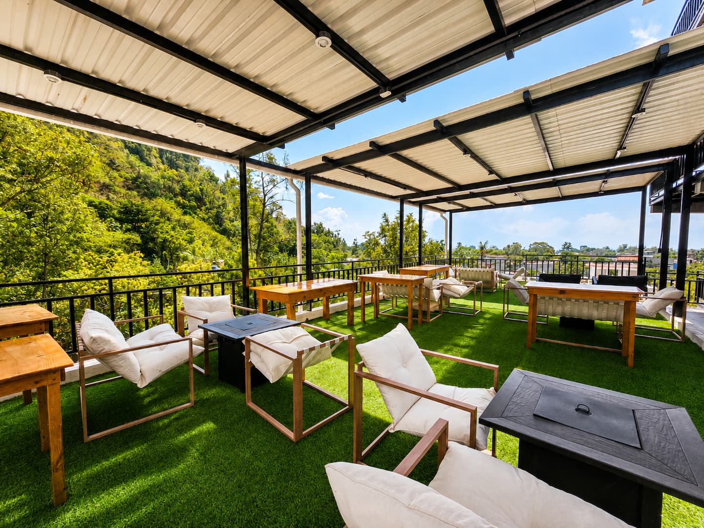 The shared rooftop terrace with lounge chairs and fire pit tables